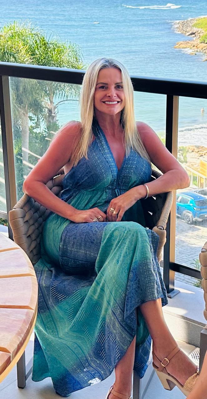 Ivana Nolan sentada em uma varanda com vista para o mar