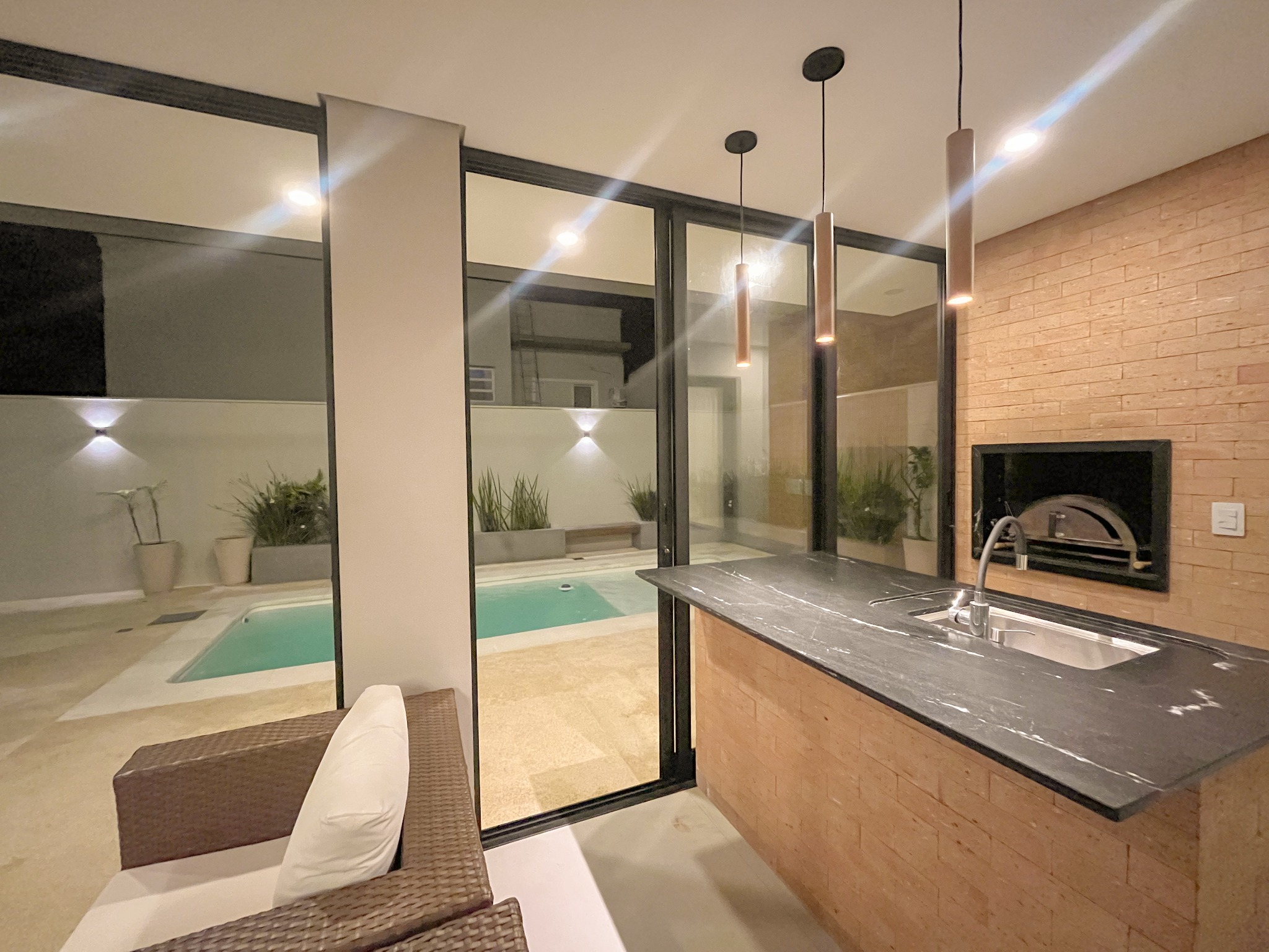 Área gourmet com lareira junto à piscina